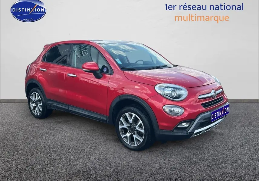 Fiat 500X rouge vue 3/4 avant droit avec jantes alu et barres de toit sur fond neutre.