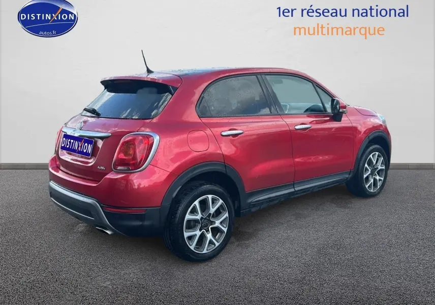 Vue 3/4 arrière droite d'un FIAT 500X rouge avec jantes alu et vitres arrière surteintées.