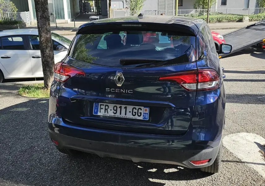 Vue arrière d'un Renault Scénic bleu cosmos métal de 2020, avec feux arrière allongés et plaque d'immatriculation française.