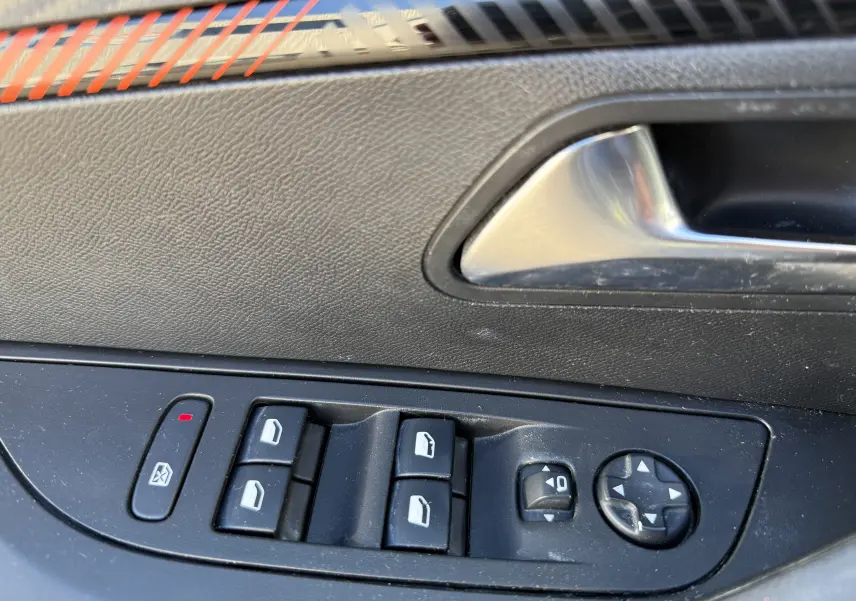 Gros plan sur les commandes des vitres et rétroviseurs côté gauche d'une Peugeot 2008 gris 1.5 HDI 2020.
