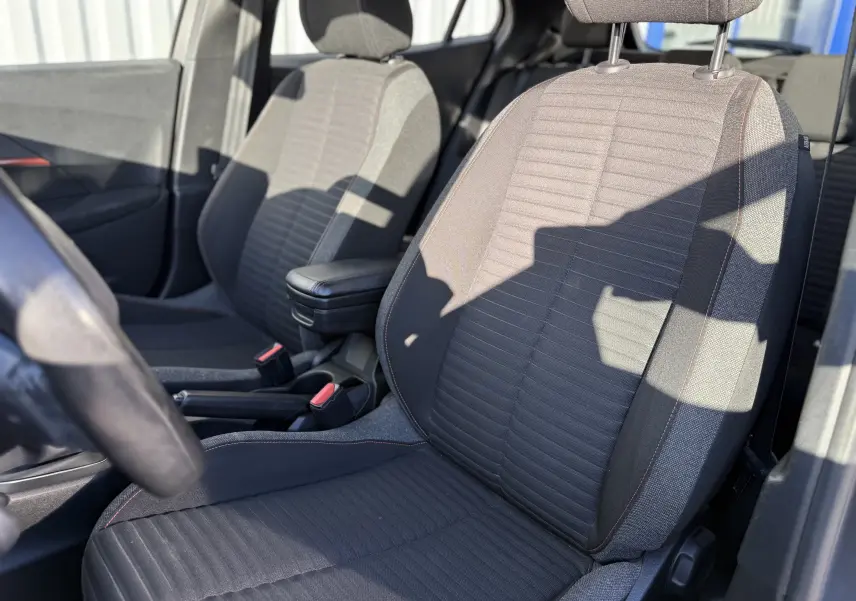 Gros plan sur les sièges avant en tissu gris foncé avec surpiqûres orange du Peugeot 2008 1.5 HDi 100 Active 2020.