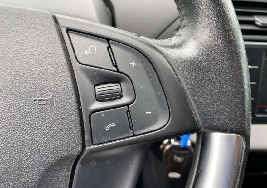 Gros plan sur les commandes du volant noir du Citroën C4 Spacetourer 2019, version diesel manuelle.