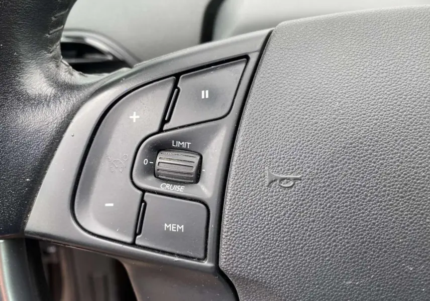 Gros plan sur les commandes de régulateur de vitesse au volant noir du Citroën C4 Spacetourer 2019.