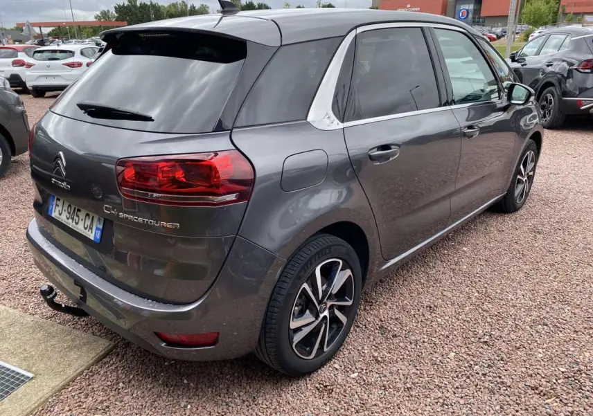 Vue 3/4 arrière droite d'une Citroën C4 Spacetourer gris métallisé avec jantes alliage et attelage visible.