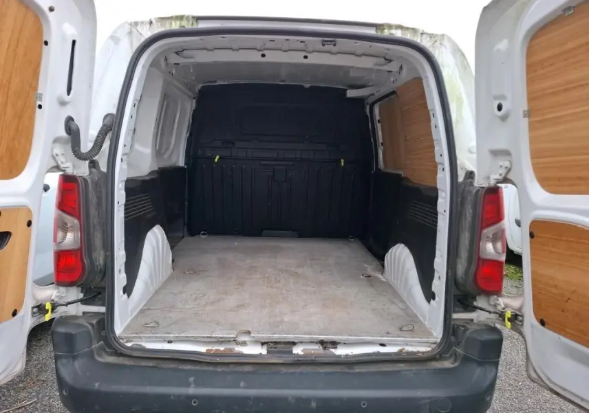 Vue arrière ouverte du Peugeot Partner blanc 2020, montrant l'espace de chargement vide avec habillage bois sur les portes.