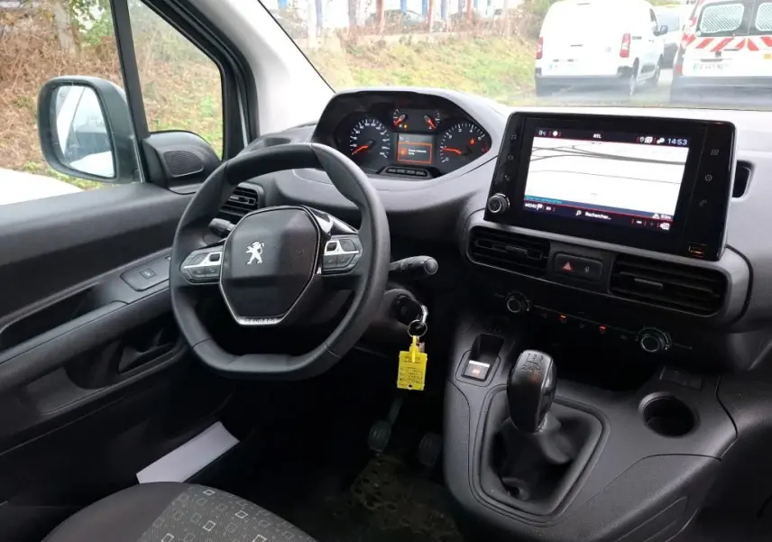Vue intérieure côté conducteur du Peugeot Partner 2020, tableau de bord avec écran tactile et levier de vitesse manuel.