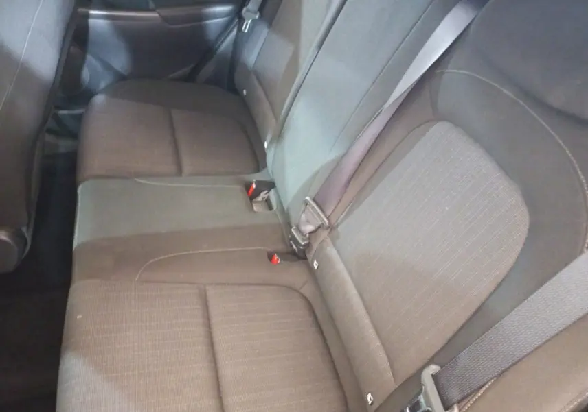 Vue intérieure sur la banquette arrière grise du Hyundai Kona 1.6 Hybrid 2022 avec ceintures de sécurité visibles.