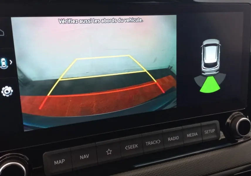 Écran tactile du système de navigation affichant la caméra de recul et l'aide au stationnement du Hyundai Kona gris foncé.