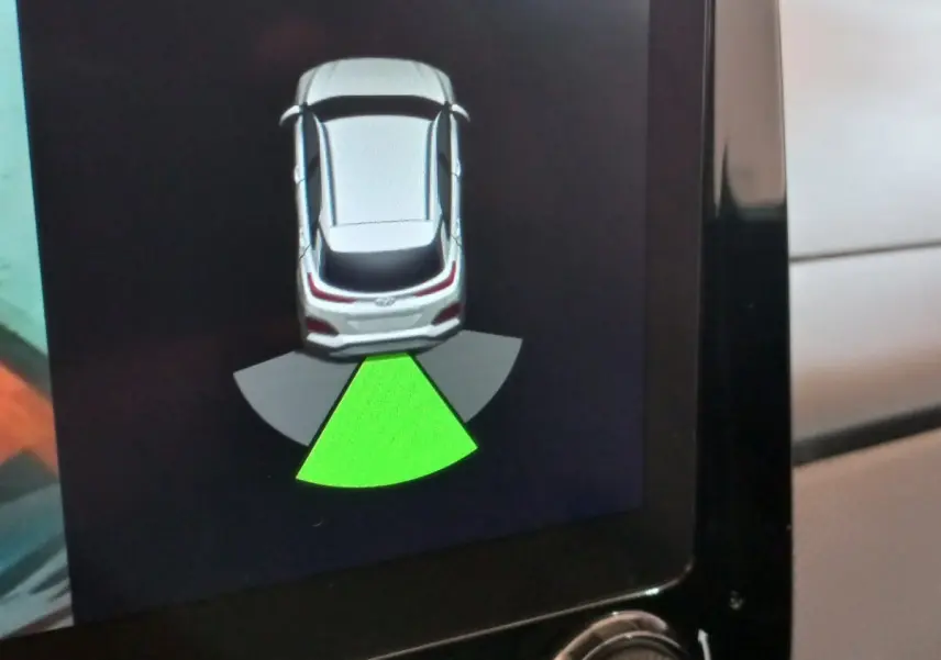 Affichage écran tactile montrant l'aide au stationnement arrière du Hyundai Kona gris foncé 2022 en vue de dessus.