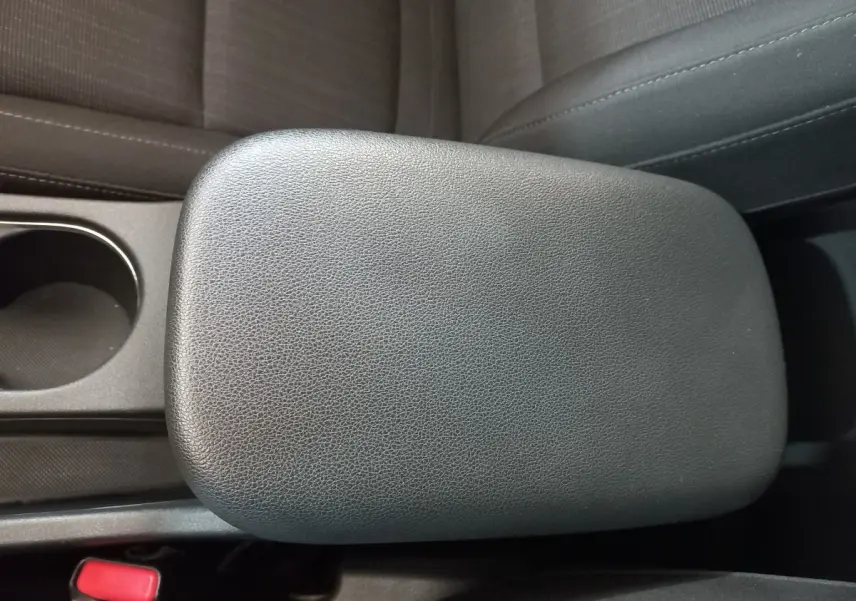 Gros plan sur l'accoudoir central en cuir noir et porte-gobelet intérieur du Hyundai Kona gris foncé 2022.