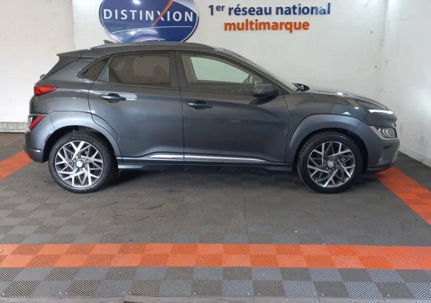 Vue de profil côté gauche d'un Hyundai Kona gris foncé 2022 avec jantes alliage et vitres teintées.