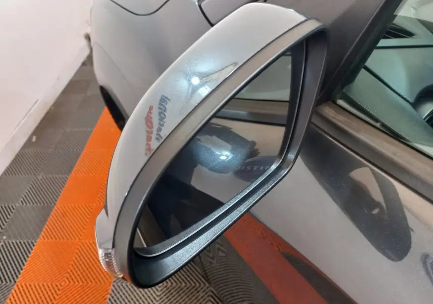 Gros plan sur le rétroviseur côté conducteur gris foncé du Hyundai Kona 1.6 Hybrid 2022, avec clignotant intégré.