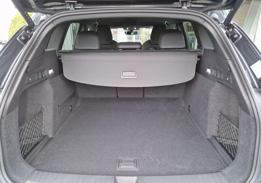 Vue arrière du coffre spacieux de l'Audi Q6 e-tron Performance S-Line gris Manhattan avec cache-bagages déployé.