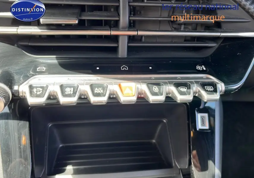 Vue rapprochée sur la console centrale noire du Peugeot 2008 2025, montrant les boutons de commande chromés.