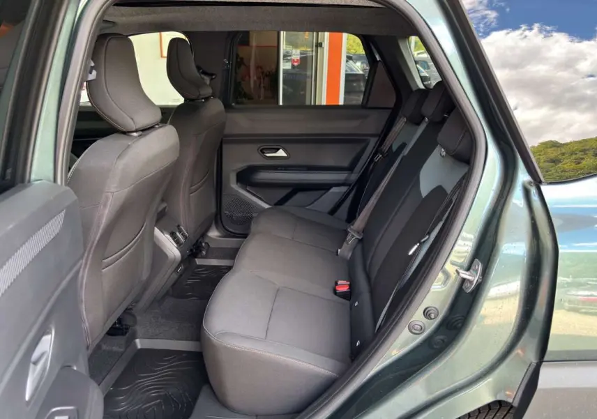 Vue intérieure côté droit des sièges arrière gris du Dacia Bigster vert cèdre avec portières ouvertes.