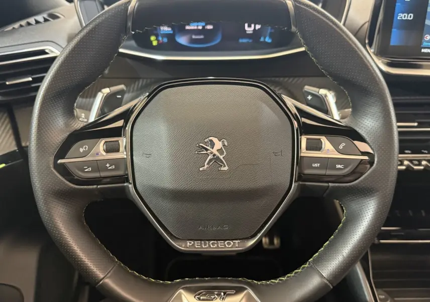 Gros plan sur le volant cuir noir du Peugeot 2008 GT PACK 2021 avec commandes intégrées et logo central.