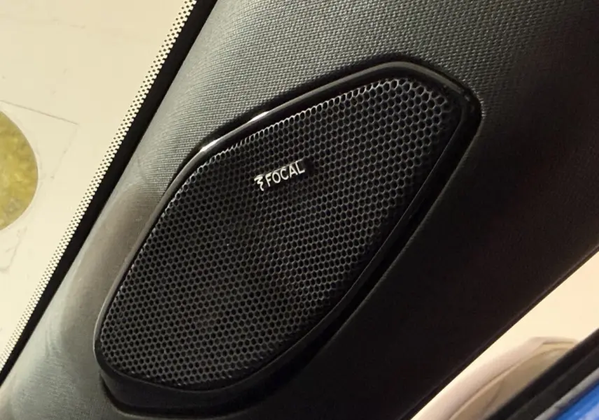 Gros plan sur l'enceinte Focal intégrée à l'intérieur côté gauche d'un Peugeot 2008 bleu 2021.