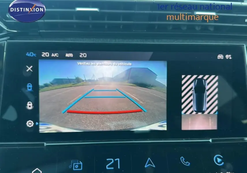 Écran tactile intérieur de la Peugeot 308 bleu clair 2021 montrant la caméra de recul et l'aide au stationnement.