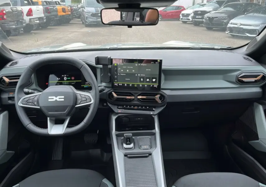 Vue intérieure du tableau de bord et volant du Dacia Bigster Hybrid 155 Extreme Plus avec écran tactile central.