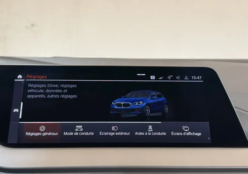 Écran tactile central affichant une BMW Série 1 bleue en 3/4 avant dans le menu Réglages du véhicule.