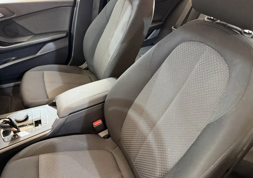 Vue rapprochée des sièges avant en tissu gris et noir de la BMW Série 1 116i Business Design 2023.
