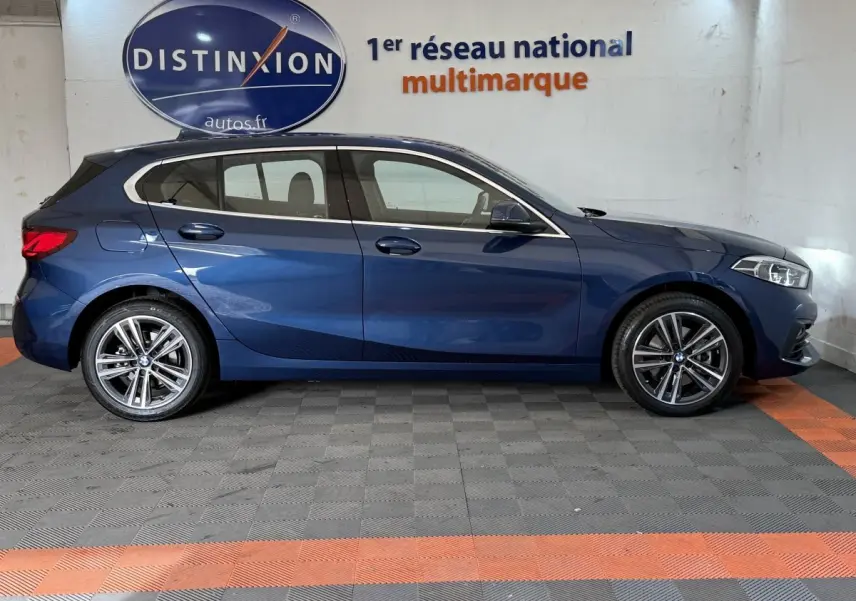 BMW Série 1 116i Business Design bleu vue de profil côté gauche, avec jantes alliage et feux arrière LED.