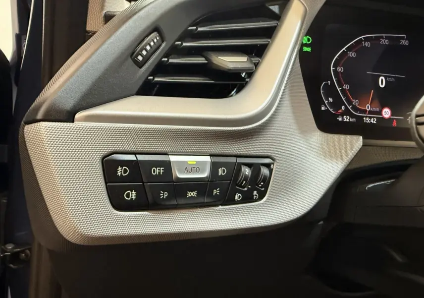 Vue rapprochée du tableau de bord côté gauche de la BMW Série 1 116i bleu, avec commandes d'éclairage et ventilation.