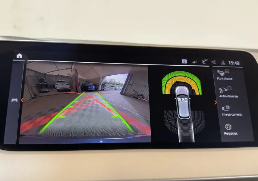 Affichage écran tactile de la BMW Série 1 bleu, vue caméra de recul avec aide au stationnement active.