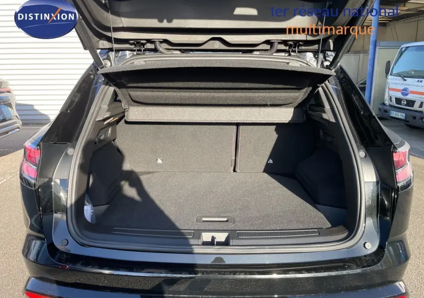 Coffre ouvert vu de l'arrière d'un Renault Austral noir étoile métal, montrant un espace de chargement spacieux et bien fini.