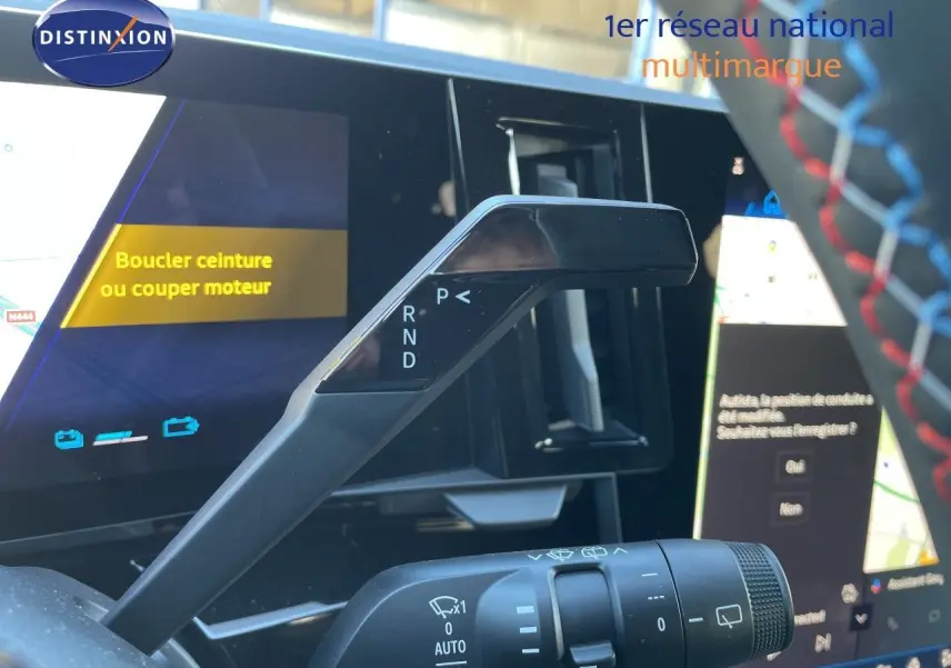 Le levier de vitesses noir du Renault Austral E-Tech, vu de près avec l'écran digital en arrière-plan.
