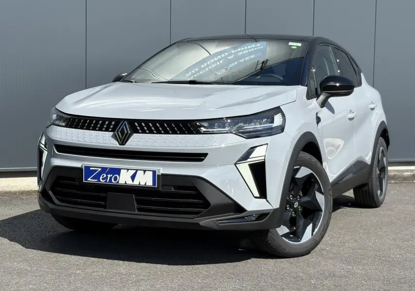 Vue 3/4 avant d'un Renault Captur gris rafale avec jantes noires et calandre moderne, sur fond neutre extérieur.