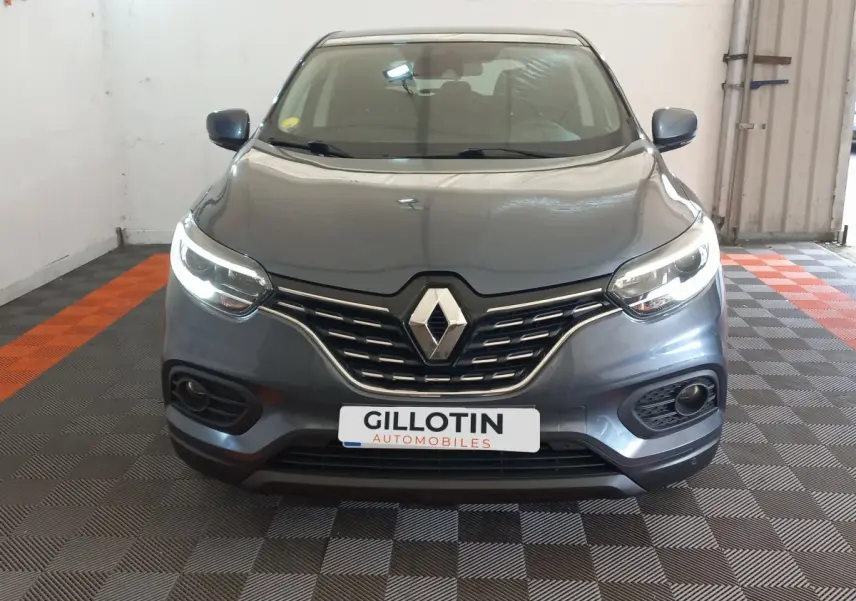 Vue frontale d’un Renault Kadjar Business gris foncé avec feux LED allumés dans un garage.
