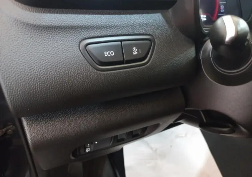 Gros plan sur les commandes ECO et arrêt auto du moteur, côté gauche du tableau de bord noir du Renault Kadjar 2022.