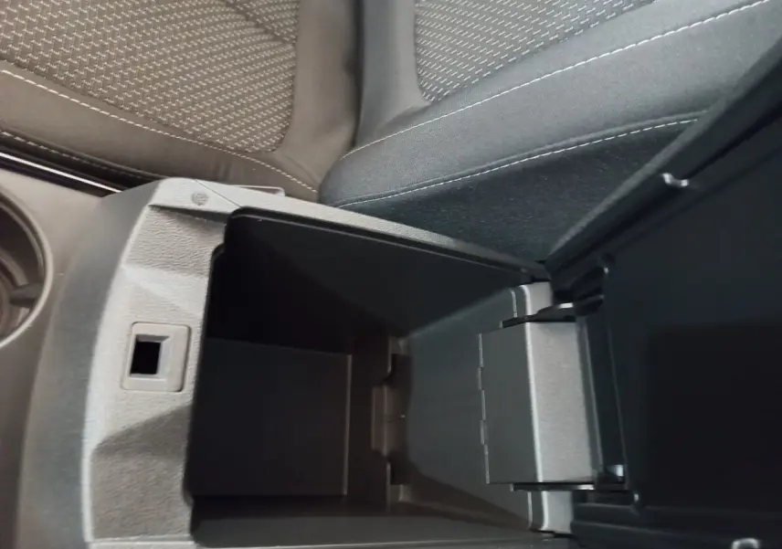 Vue intérieure en gros plan du rangement central ouvert entre les sièges tissu gris du Renault Kadjar Business 2022.