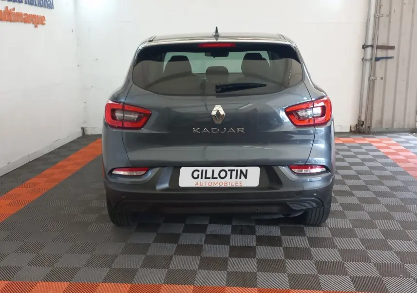 Vue arrière d'un Renault Kadjar gris foncé 2022 dans un garage avec sol à damier gris et orange.