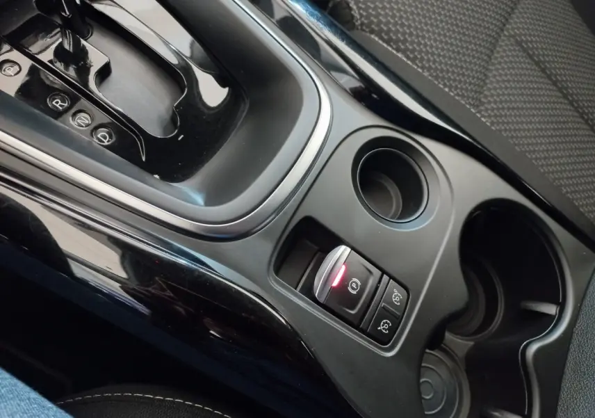Gros plan sur la console centrale noire du Renault Kadjar 2022, montrant levier de boîte auto et boutons de frein à main électrique.