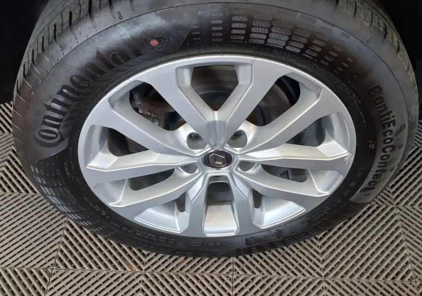 Gros plan sur la roue avant droite du Renault Kadjar gris foncé, jante alliage argentée avec logo Renault central.