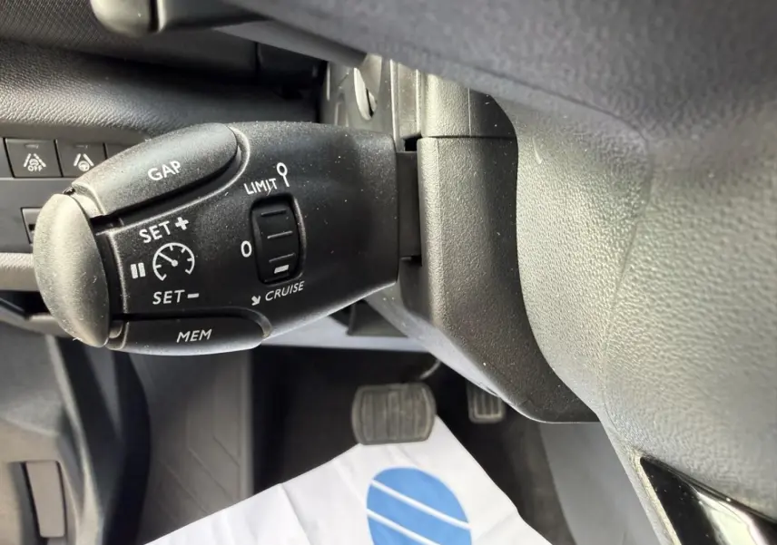 Gros plan sur la commande de régulateur de vitesse du Citroën C5 Aircross 2024 noir métal, côté gauche du volant.