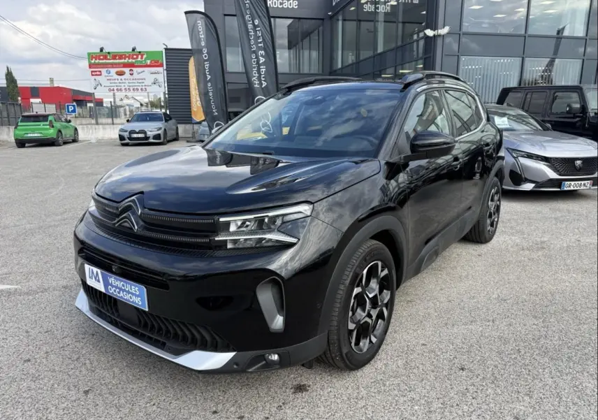 Citroën C5 Aircross 1.2 Hybride 145 cv noir métal, vue 3/4 avant droit avec jantes spécifiques et calandre distinctive.