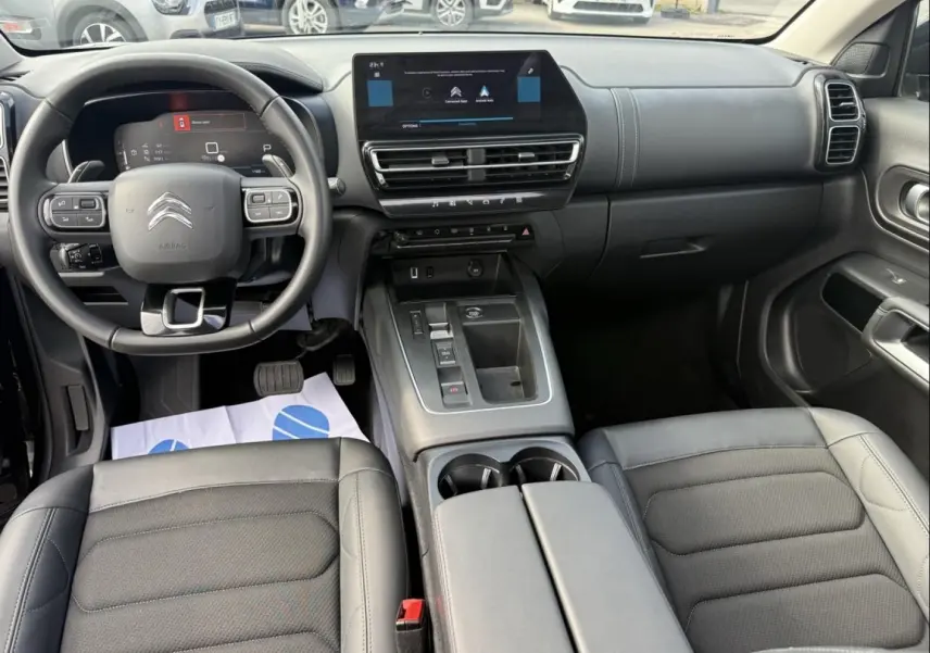 Vue intérieure avant du Citroën C5 Aircross 2024 noir métal, avec tableau de bord numérique et console centrale moderne.