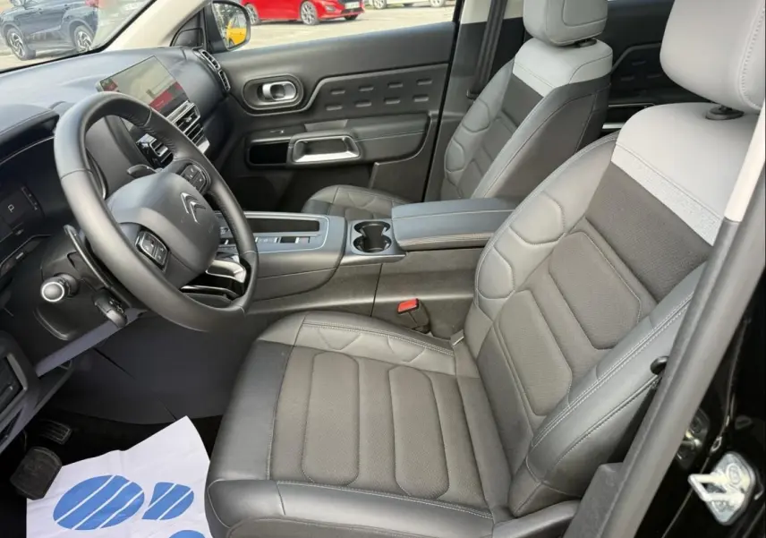 Vue intérieure côté conducteur du Citroën C5 Aircross 2024 noir métal, avec sièges cuir bi-ton et tableau de bord moderne.