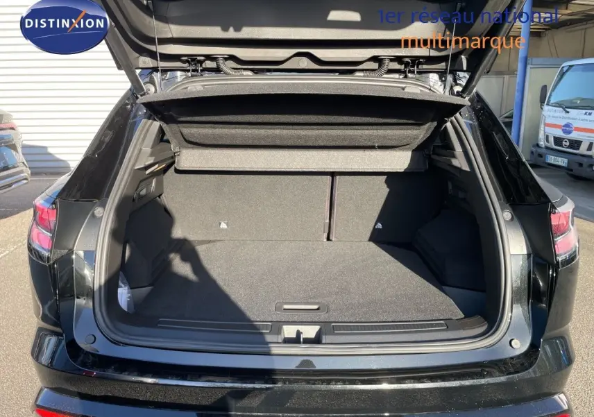 Coffre ouvert vu de l'arrière d'un Renault Austral E-Tech Full Hybrid noir étoile métal, montrant l'espace de chargement vide.