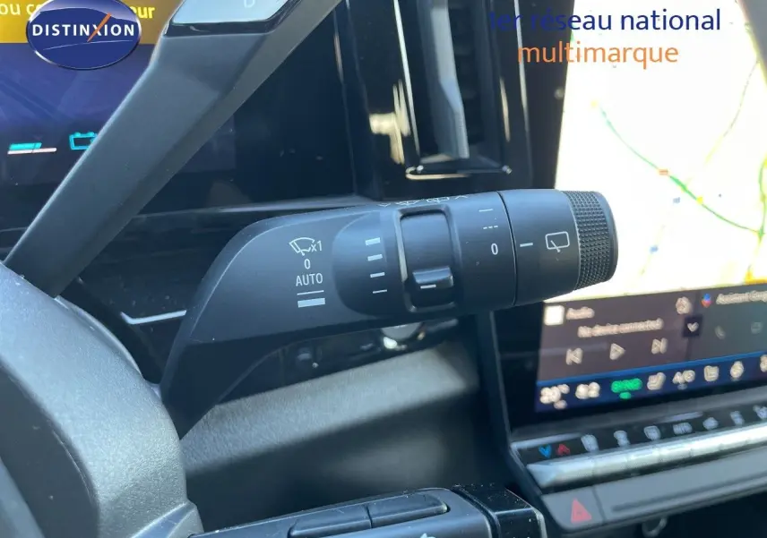 Détail du commodo d’essuie-glace côté gauche dans l’habitacle du Renault Austral noir étoile métal, avec écran tactile en arrière-plan.