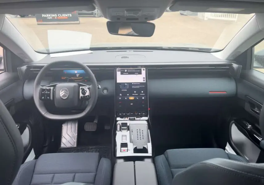 Vue intérieure avant du Citroën C5 Aircross Hybrid 2026, tableau de bord noir avec écran tactile vertical et volant cuir multifonctions.