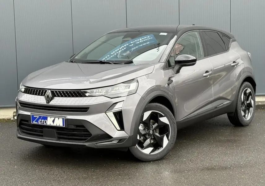 Renault Captur Gris Cassiopée en 3/4 avant droit, toit noir étoilé et jantes aluminium noires distinctives.
