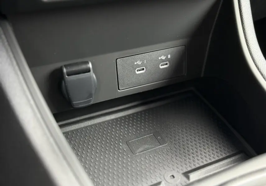 Gros plan sur la console centrale du Renault Captur 2025 avec ports USB-C et chargeur sans fil intégré.
