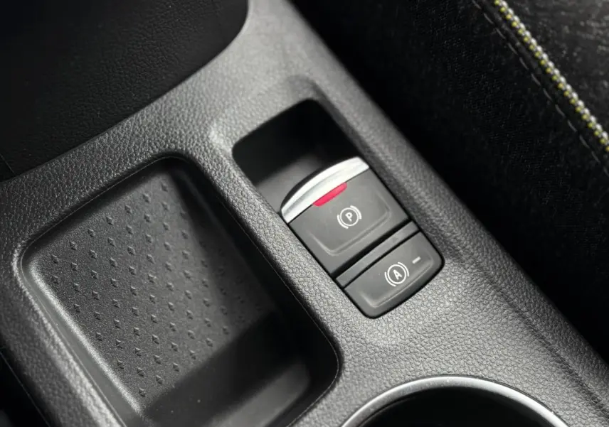 Gros plan sur la console centrale noire du Renault Captur 2025 avec frein de parking électrique et bouton Auto-Hold.