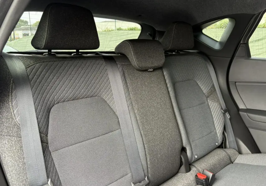 Vue intérieure sur la banquette arrière gris foncé du Renault Captur 2025 avec appuis-tête et ceintures de sécurité visibles.