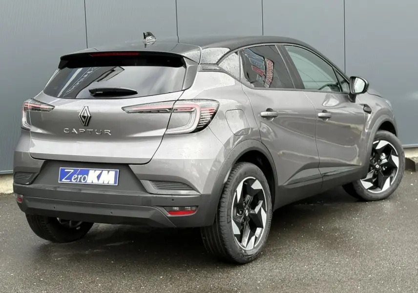 Vue 3/4 arrière droite d'un Renault Captur gris Cassiopée avec toit noir étoilé et jantes aluminium 18 pouces.