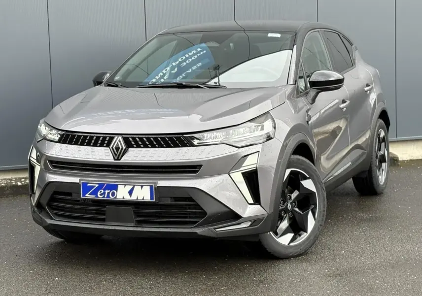 Renault Captur 2025 gris Cassiopée vu de face droite, avec calandre moderne et jantes aluminium noires.